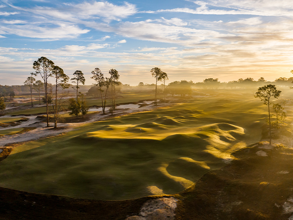 Sunrise over the rolling terrain and sandy fairways at Cabot Citrus Farms